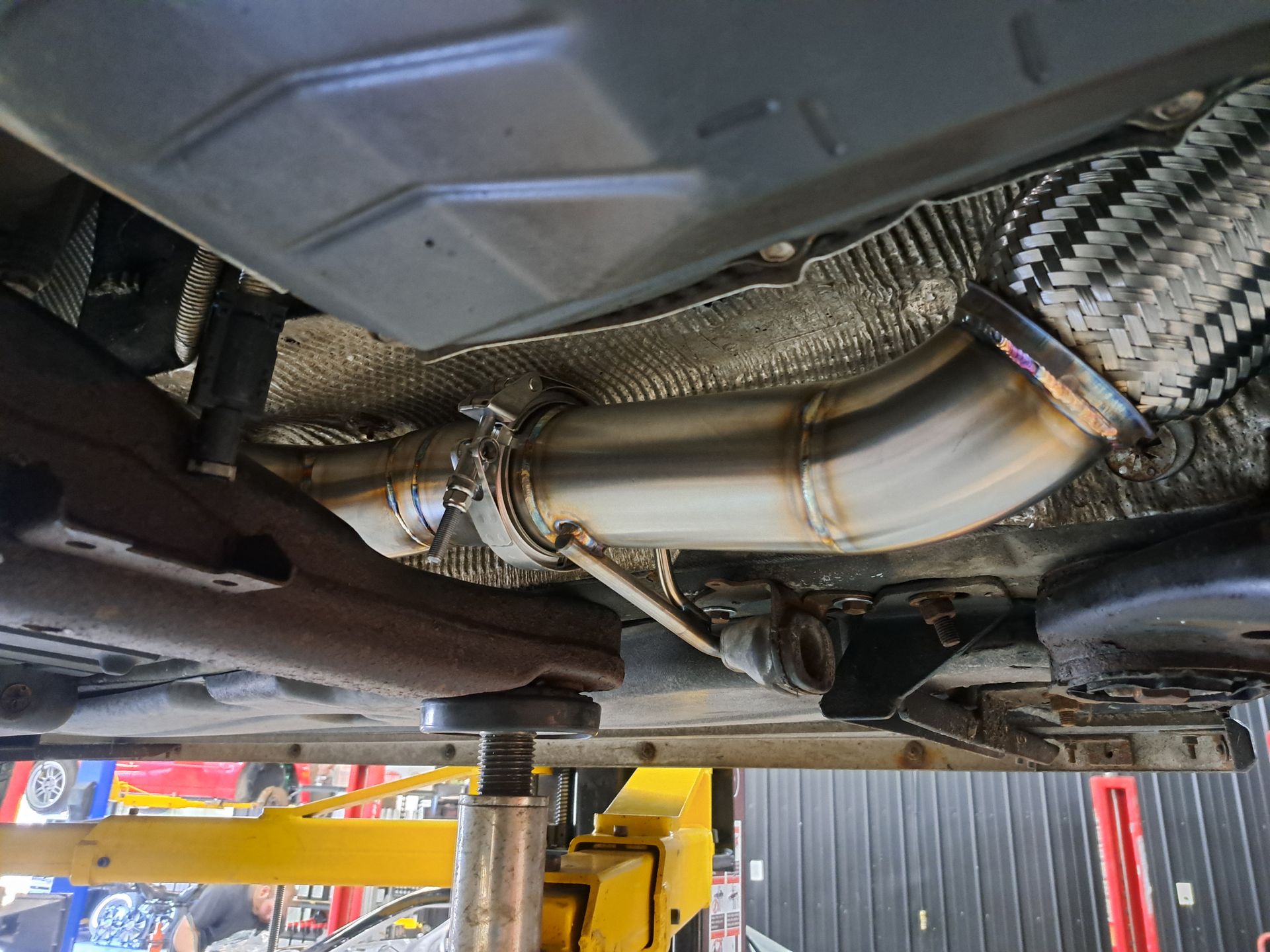 Downpipe stainless fabriqué sur mesure et installé sur un véhicule performance